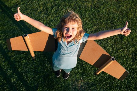 Photo for Excited dreamer boy playing with a cardboard airplane. Kid dreams of future. Kid pilot dreaming. Childhood dream concept. Blonde cute daydreamer child dream on fly. Dreams and imagination - Royalty Free Image
