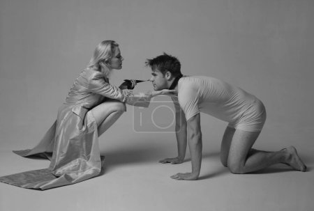 Photo for Dominatrix blonde woman holding her husband in collar and make him obey. Loving couple play in love sex games. Dominate, obey, undress and seduce a partner concept - Royalty Free Image