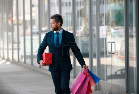 Photo for Portrait of an handsome businessman walking with shopping bag in a business center - Royalty Free Image