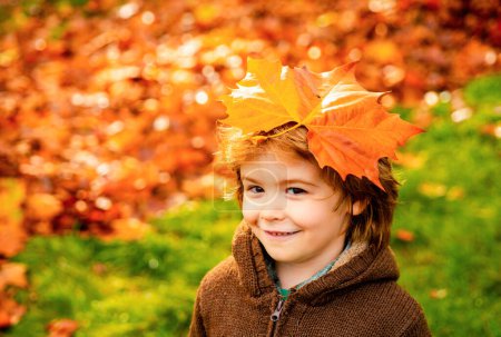 Téléchargez les photos : Enfant de 5 ans couché sur la feuille d'or. Portrait d'automne en plein air de mignon garçon heureux enfant marchant dans le parc ou la forêt en tricot chaud Vêtements - en image libre de droit