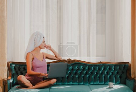 Photo for Young attractive woman working on computer at home. Beautiful girl using laptop computer in the mornig on the bed - Royalty Free Image
