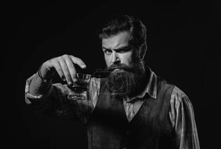 Téléchargez les photos : Homme élégant et élégant dans l'usure classique tenant verre avec whisky à la main - en image libre de droit