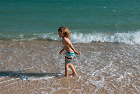 Foto de Niño saltando en olas marinas. Saltar por el agua salpicaduras de mar. Vacaciones de verano para niños - Imagen libre de derechos