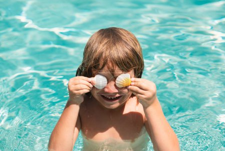 Foto de Feliz niño jugando en la piscina. Concepto vacaciones de verano. Ojos cubiertos con conchas - Imagen libre de derechos