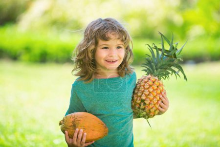 Photo for Child with pineapple and coconut. Kid with tropical fruit. Exotic vacation. Fruit for children. Summer kids holiday - Royalty Free Image