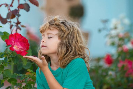 Téléchargez les photos : Enfant sentant la fleur. Un drôle de visage. Enfant mignon profiter de l'environnement naturel grâce à l'activité de plein air comme jouer, toucher et sentir rose - en image libre de droit