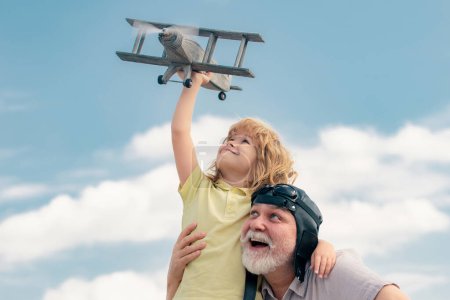 Photo for Grandfather and son enjoying play with plane together on blue sky. Family dream. Child dreams with plane. Grandfather and child son dream. Daydreamers. Dreams and imagination. Dreamy son - Royalty Free Image