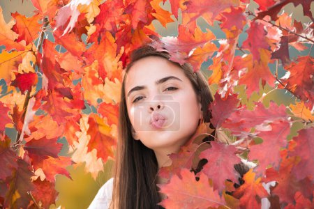 Foto de Mujer joven en el parque de otoño. Clima cálido y soleado. Concepto de caída. Hola otoño. Mujer feliz con hojas amarillas de otoño afuera. Hermoso otoño tiempo de otoño en la naturaleza - Imagen libre de derechos