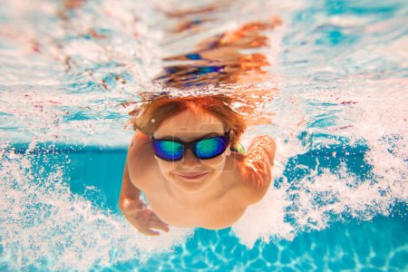 Photo for Summer child boy relax at aquapark. Summertime vacation. Little kid swim underwater in pool. Kid wearing summer goggles swims under water in poolside. Underwater photo - Royalty Free Image