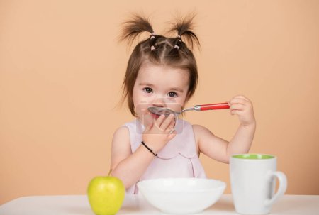 Foto de Bebés comiendo, comida saludable para un bebé. Niña comiendo comida saludable - Imagen libre de derechos
