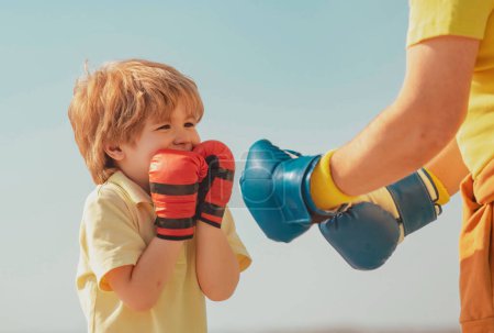 Photo for Boxer grandfather and child with blue boxing glove on blue sky background - isolated. Grandfather and grandson doing boxing training in morning - Royalty Free Image