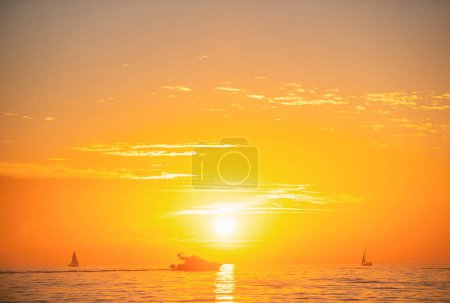 Foto de Paisaje marino amanecer dorado sobre el mar. Naturaleza paisaje. Hermoso color naranja y amarillo en la puesta de sol del océano. Paisaje marino con cielo dorado y nubes - Imagen libre de derechos