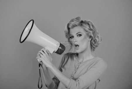 Photo for Blonde woman in retro style shouting through a megaphone. Beauty woman with megaphone isolated on pink - Royalty Free Image