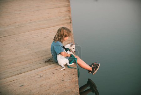 Téléchargez les photos : Joyeux enfant avec chien. Enfance insouciante. Protection des animaux domestiques - en image libre de droit