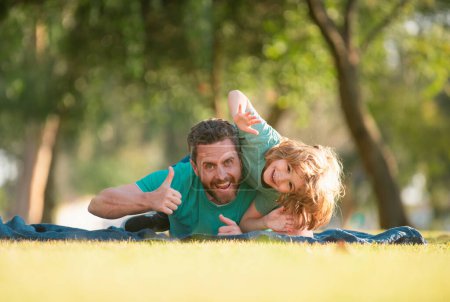 Photo for Happy father and son enjoying summer time on vacation in a sunny park - Royalty Free Image