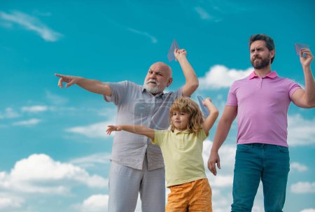 Foto de Abuelo padre e hijo jugando con avión de juguete al aire libre en el cielo. Familia feliz. Tres generaciones de hombres. Feliz infancia. Viaje viaje viaje concepto de viaje - Imagen libre de derechos