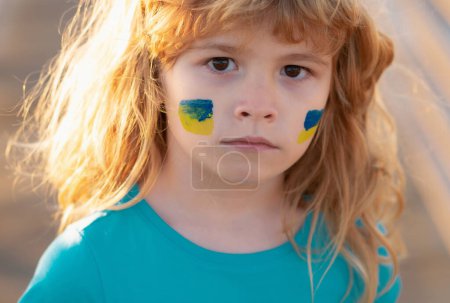 Téléchargez les photos : Drapeau Ukraine sur la joue des enfants. Pas de guerre, arrêter la guerre, agression russe. Petit patriote ukrainien - en image libre de droit