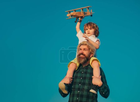 Photo for Happy father giving shoulder ride on his shoulders. Father and son together. Boy child is sitting on daddy shoulder piggyback while the flight - Royalty Free Image
