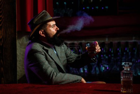 Téléchargez les photos : Un homme séduisant avec une cigarette et un whisky - en image libre de droit