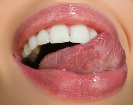 Foto de Cuidado dental, dientes sanos y sonrisa, dientes blancos en la boca. Primer plano de sonrisa con dientes blancos y sanos. Abre la boca, la lengua toca los dientes - Imagen libre de derechos