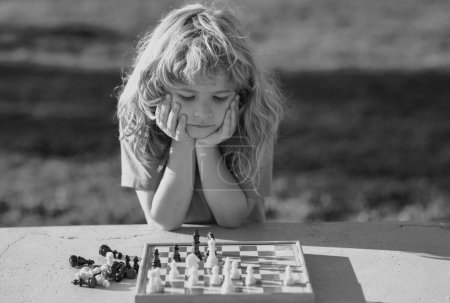 Foto de Kid Playing Chess. Intelligent, smart ass kids. Games good for brain intelligence concept - Imagen libre de derechos