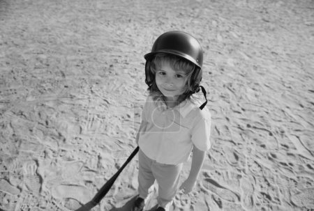 Téléchargez les photos : Petit garçon posant avec une batte de baseball. Portrait d'un enfant jouant au baseball - en image libre de droit