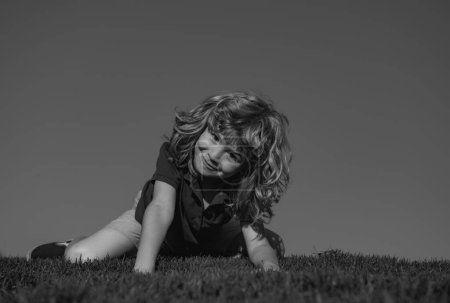 Téléchargez les photos : Enfant garçon profiter sur le champ d'herbe et rêver - en image libre de droit