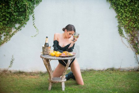 Photo for Sexy young woman with vegetables and fruits outdoors. Romantic young woman posing sexy outdoor. Sexy woman near picnic table with fruits and vegetables - Royalty Free Image