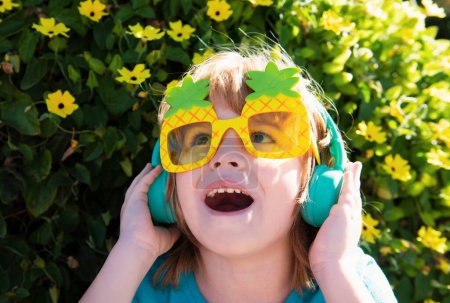Foto de Feliz verano. Un chico escuchando música. Niño con gafas de sol locas. Niño feliz en gafas de fiesta - Imagen libre de derechos