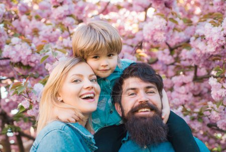 Photo for Happy family outdoors. Mother father and son. Spring time. Portrait of happy family in blooming Garden - Royalty Free Image