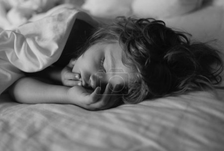 Téléchargez les photos : Adorables petits enfants se reposent endormis profiter d'un bon sommeil paisible en bonne santé ou la sieste. Enfant de six ans dormant au lit - en image libre de droit