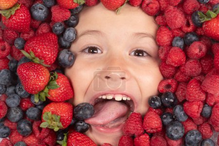 Téléchargez les photos : Mélange assorti de fraise, myrtille, framboise, fond de mûre. Les baies se rapprochent du visage des enfants. Des baies fraîches, vue de dessus. Mélange de fruits crus de baies fraîches - en image libre de droit