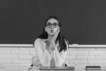 Photo for Funny female student with air kiss in school classroom. Cute school girl - Royalty Free Image