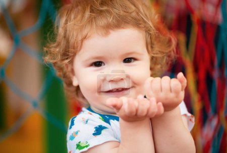 Téléchargez les photos : Portrait d'un enfant heureux et riant sur une aire de jeux. Gros plan positif enfants visage - en image libre de droit