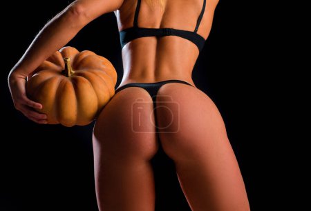 Foto de Lingerie model. Sexy Halloween. Fashion style of naked wowan with pumpkin and sexy ass buttocks - Imagen libre de derechos
