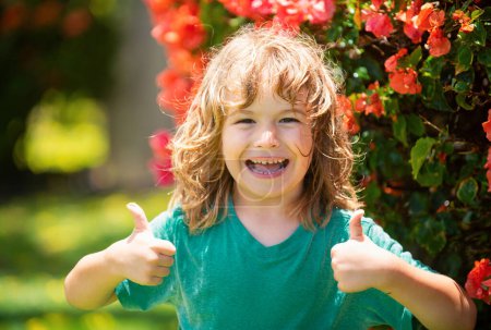 Foto de Retrato de un niño feliz riendo. Cerca de cara positiva de los niños, pulgares hacia arriba signo - Imagen libre de derechos