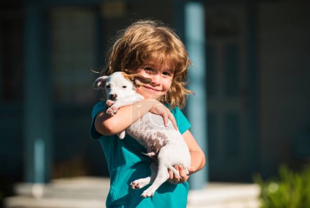Téléchargez les photos : Câlin amis, enfant câlin chien. Joyeux câlins d'enfant et de chiot avec tendresse souriante - en image libre de droit