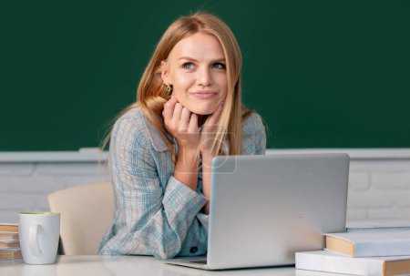 Photo for Female student on lesson lecture in classroom at high school or college. Creative young smiling female student using laptop - Royalty Free Image