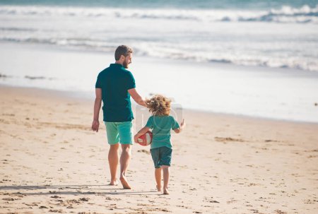 Foto de Papá y su hijo se divierten al aire libre. Padre e hijo caminando en la playa de verano. Concepto de infancia y crianza - Imagen libre de derechos