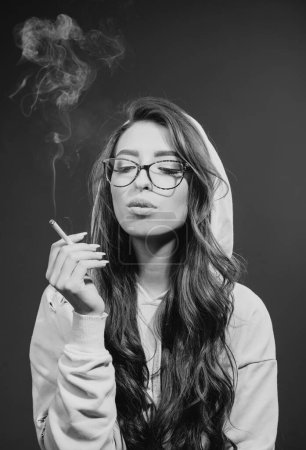 Foto de El cáncer cura fumar. Una mujer bonita con el pelo largo fumando cigarrillo. Sensual adicto al tabaco o fumador. Hábitos de fumar para mujeres
. - Imagen libre de derechos
