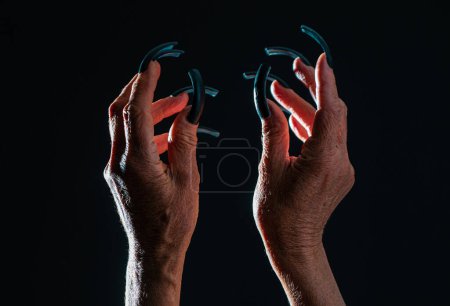 Photo for Old woman hands. Elderly woman, wrinkled hand. Old lady arms, freckles. Isolated black background. Female old scary mystic hands with long black nails of witch zomby devil on halloween holiday - Royalty Free Image