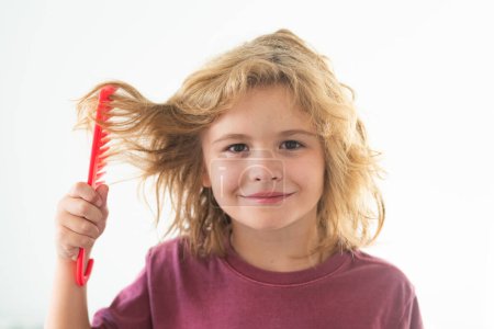 Photo for Boy brushes his hair. Little kid combing hair, isolated studio background - Royalty Free Image