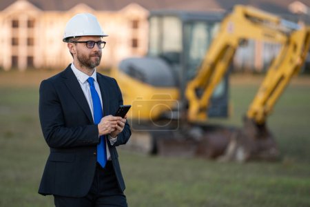 Photo for Supervisor in suit and helmet. Investor civil engineer, construction manager at a construction. Construction building developer at a construction site. Successful architect. Handsome builder man in - Royalty Free Image