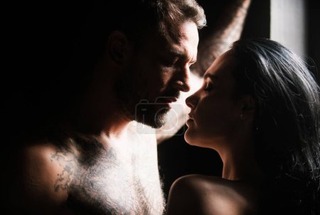Couple of young lovers kissing. Young couple of attractive woman and naked muscular man kissed in studio background. Couple in love. Beautiful lovers kiss