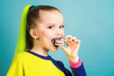 Photo for Yang kid having a snack breaks with delicacy macaroon. Pastry macaroon. Kid eats tasty macaroon cookies. Cooking, confectionery, food and baking concept - Royalty Free Image