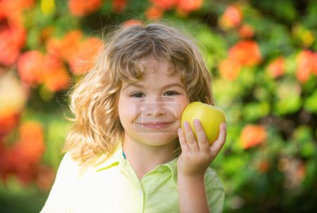 Photo for Child kid eating apple fruit outdoor autumn fall nature healthy outdoors - Royalty Free Image