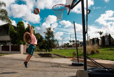 Photo for Cute little boy child jumping with basket ball for shot. Sport for kids outside. Basketball kids school - Royalty Free Image