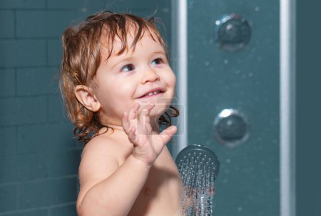 Téléchargez les photos : Enfant dans une baignoire. Bébé drôle enfant baigné de mousse et se lavant dans la baignoire à la maison - en image libre de droit