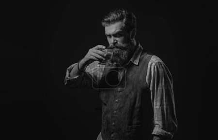 Foto de Un camarero sosteniendo un vaso de whisky. Whisky elegante. Barbudo y vaso de whisky. Barman o barman sirve coñac - Imagen libre de derechos