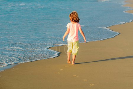 Foto de Un niño jugando en el océano. Vacaciones de verano en la playa. Niños vacaciones de verano en la playa - Imagen libre de derechos